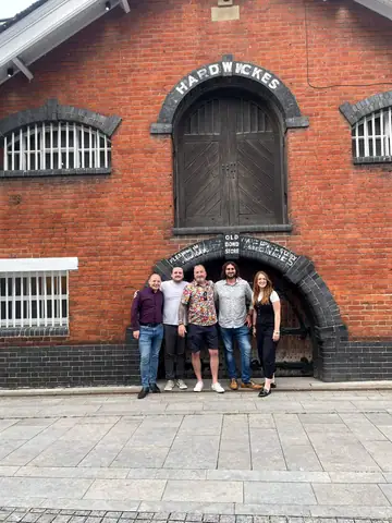 Group outside a building, behind the scenes with Mark Staples